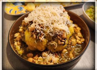 Gerookte bloemkool van de barbecue met kruidenboter, geroosterde macadamia & pijnboompitten en gruyère